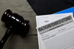 healthcare power of attorney text on document and gavel isolated on office desk